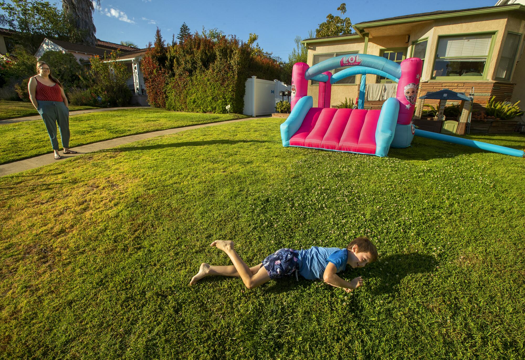 Jay Bass, 6, rolls over and over while playing on a front lawn
