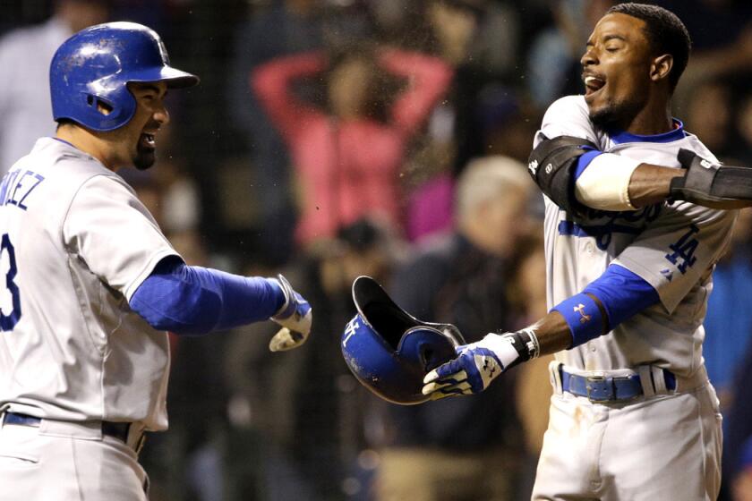 Dodgers second baseman Dee Gordon, right, celebrates with first baseman Adrian Gonzalez after scoring against the Cubs on a hit by Yasiel Puig in the seventh inning Thursday night in Chicago.