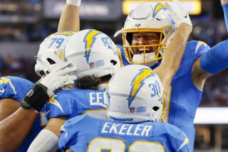 Chargers quarterback Justin Herbert (right) joins the celebration after throwing a touchdown pass in the first quarter.