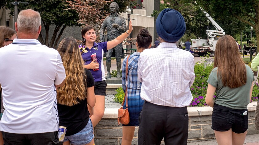 A James Madison University tour guide leads a group of prospective high school students around campus on Aug. 1, 2016, in Harrisonburg, Va.