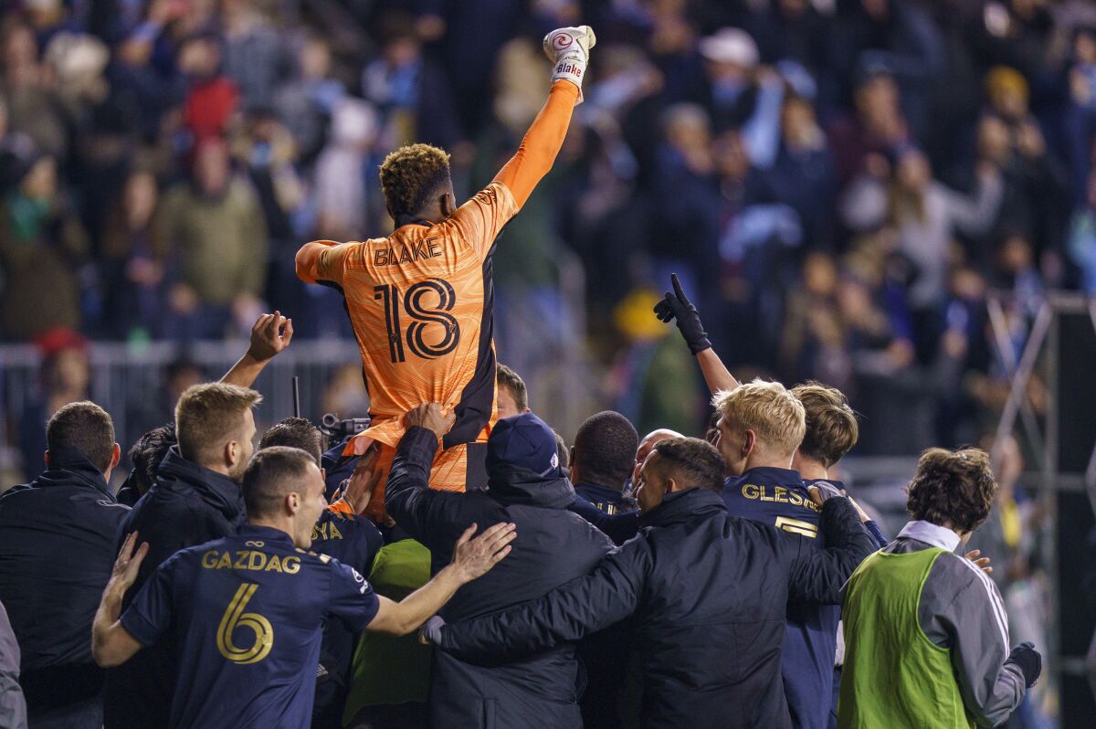 Philadelphia Union's Andre Blake (18) is lifted by teammates following the shootout of an MLS playoff soccer match against Nashville SC, Sunday, Nov. 28, 2021, in Chester, Pa. (AP Photo/Chris Szagola)