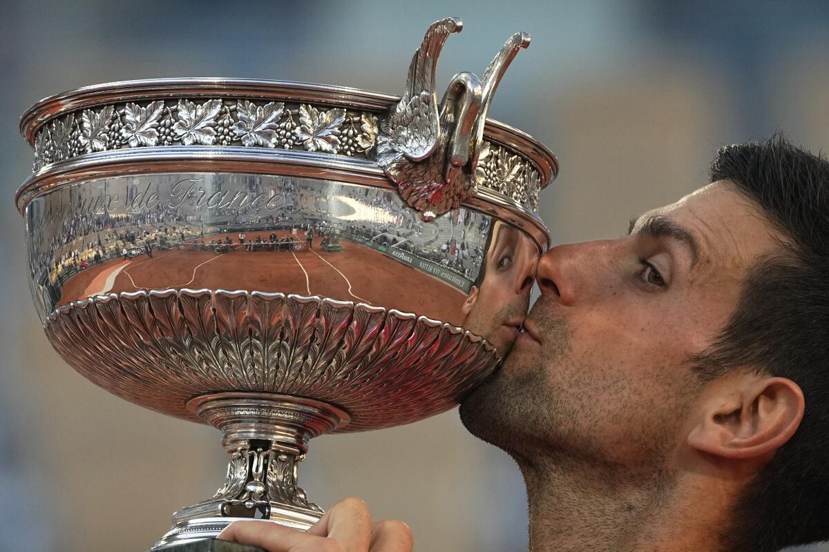 Serbia's Novak Djokovic kisses the cup after defeating Stefanos Tsitsipas of Greece during their final match of the French Open tennis tournament at the Roland Garros stadium Sunday, June 13, 2021 in Paris. Djokovic won 6-7 (6), 2-6, 6-3, 6-2, 6-4. (AP Photo/Michel Euler)