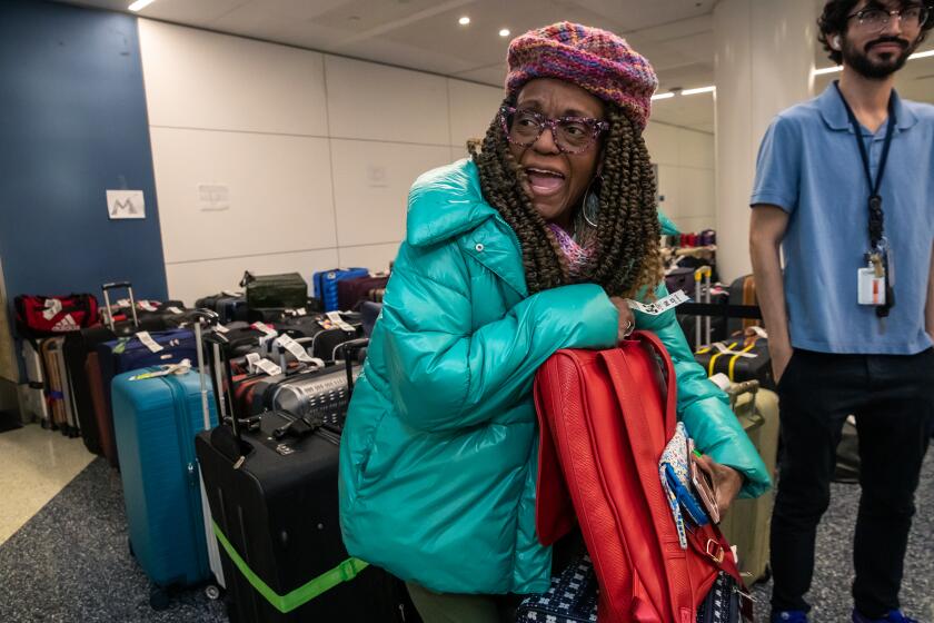 Los Angeles, CA - December 28: Theresa Matthews, 61, is happy to locate her backpack carrying her laptop that has her doctorate work papers. Matthews drove 33 hours straight from Nashville to Los Angeles after their Southwest flight got canceled. Passengers effected by cancellation of more than 2,500 flights nationwide, passengers who took hours of driving to reach LAX look for their luggage at LAX Southwest Terminal 1 on Wednesday, Dec. 28, 2022 in Los Angeles, CA. (Irfan Khan / Los Angeles Times)