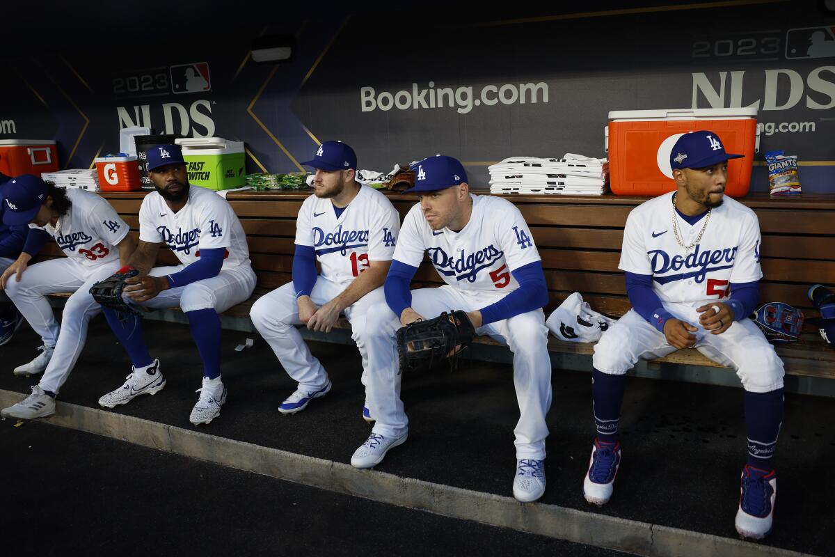 Dodgers players (from left) James Outman, Jason Heyward, Max Muncy, Freddie Freeman and Mookie Betts sit in the dugout.