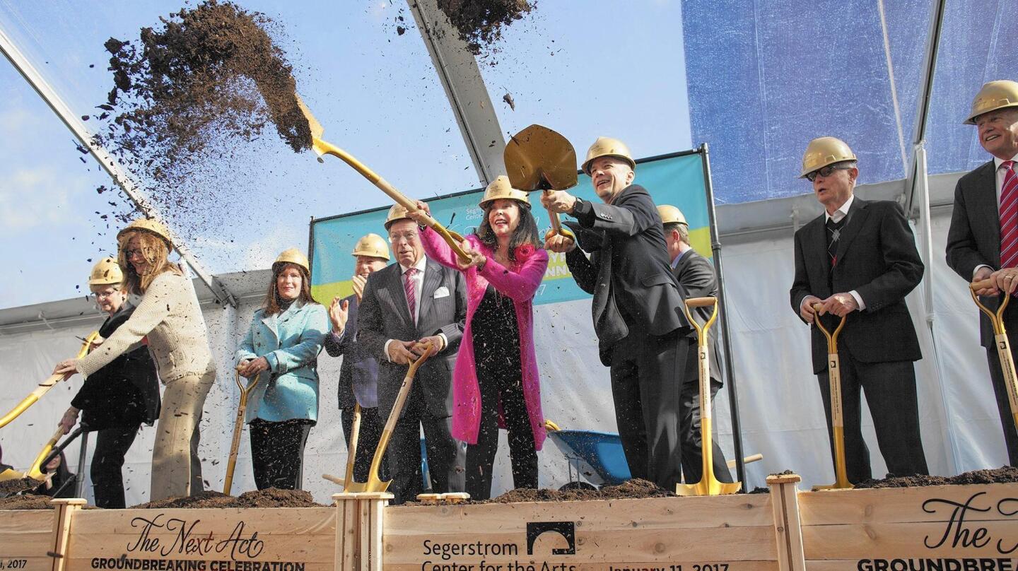 Julianne Argyros, center, stands between her husband, George, left, and project architect Michael Maltzan, right, as they shovel dirt with other dignitaries during a reception and ceremony for Segerstrom Center for the Arts' new Julianne and George Argyros Plaza and the Center for Dance and Innovation in Costa Mesa on Wednesday.