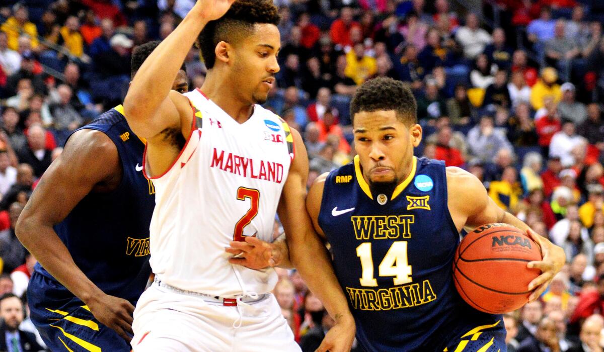 West Virginia guard Gary Browne drives against Maryland guard Melo Trimble, who would later leave with a head injury, during the second half of the Mountaineers' 69-59 victory on Sunday.