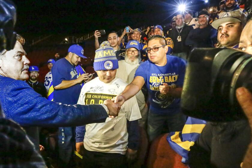 Rams Coach Jeff Fisher, left, greets fans before a news conference at the Forum in Inglewood on Jan. 15.