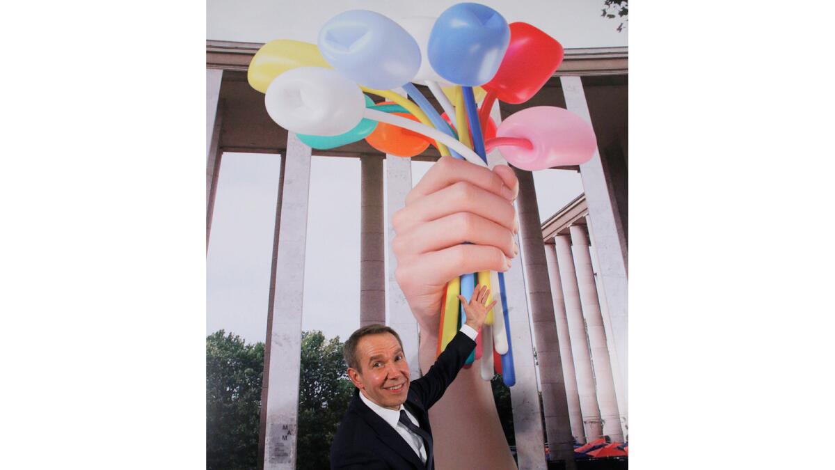 Jeff Koons poses next to a rendering of his proposed sculpture during an event at the American Embassy in Paris.