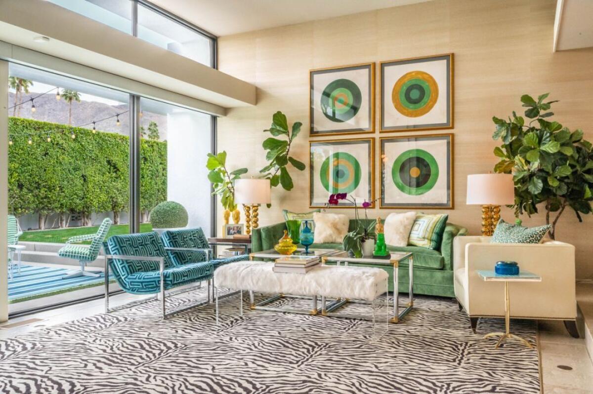 A living room with blue chairs and a green couch. 