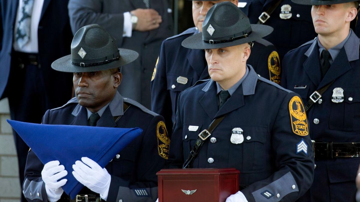 Virginia State Police carry a flag and remains of Trooper Berke Bates, who was killed in a helicopter crash during protests in Charlottesville, at his funeral on Friday. The funeral for the other trooper who died, Lt. Jay Cullen, was held Saturday.