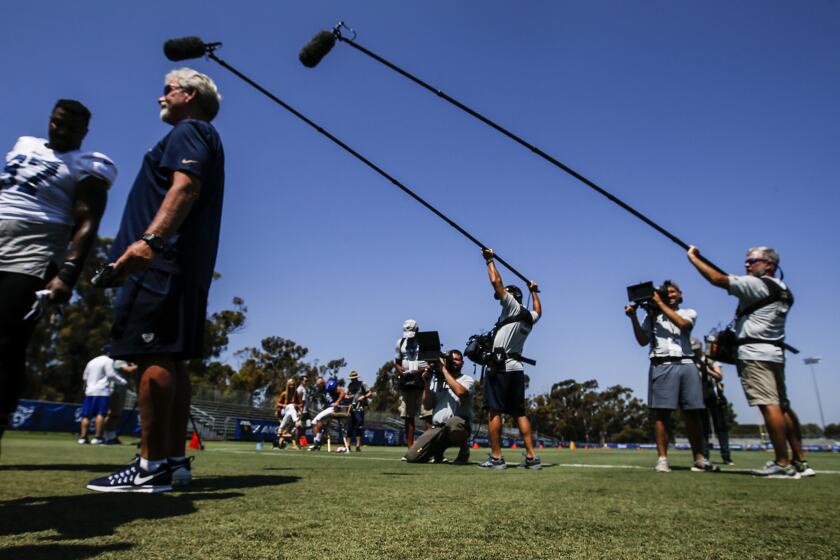 Two boom microphones record the all-important sounds while camera crews document a Rams practice at their training camp in Irvine on Aug. 1 for the HBO show "Hard Knocks."
