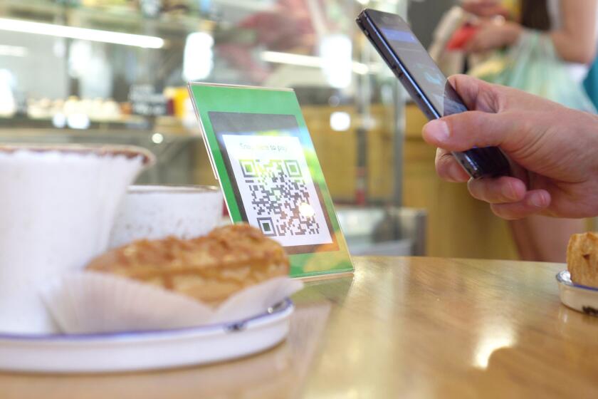 someone scanning a QR code at a coffeeshop