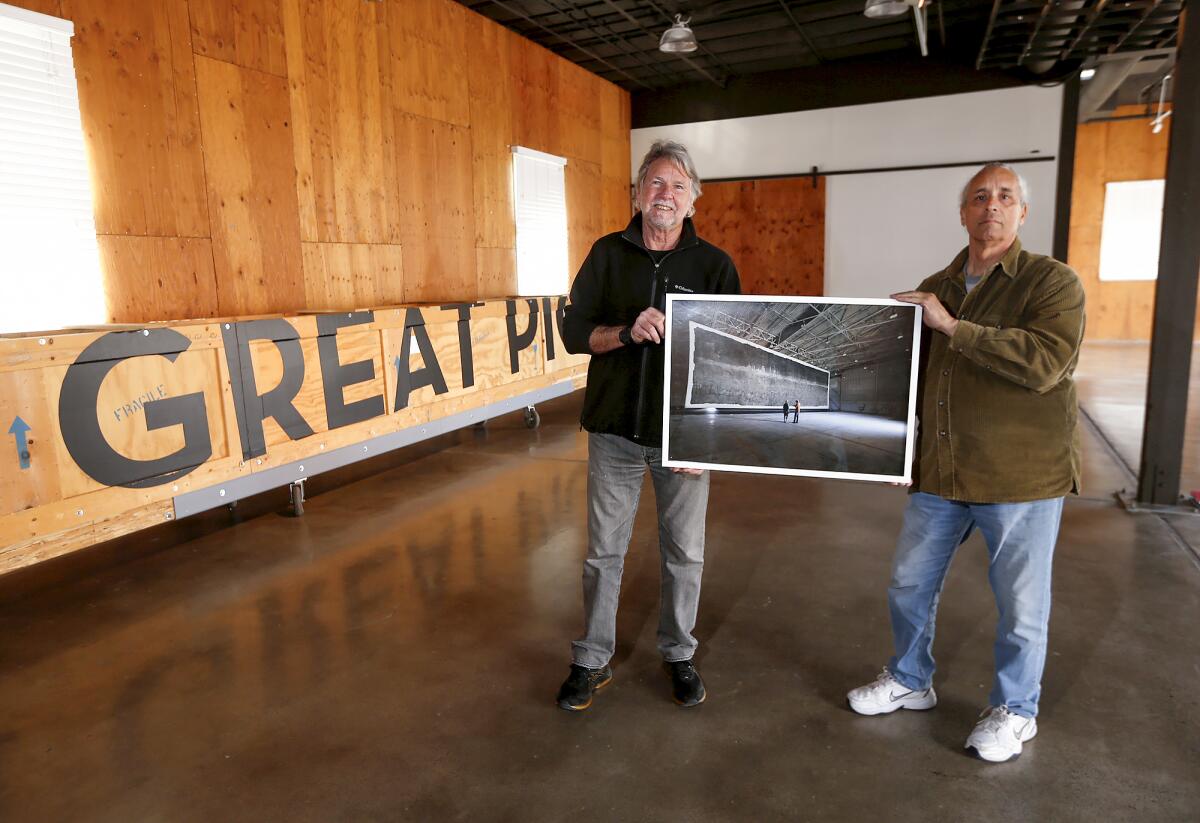 Jacques Garnier and Clayton Spada hold an image of their photograph.