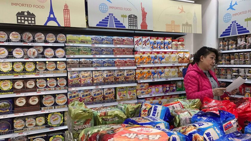 In this March 17 file photo, a vendor takes stock of imported food at a mall in Beijing.