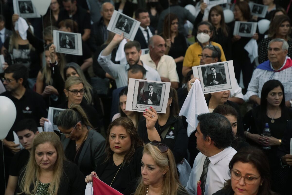 ARCHIVO - Personas, sosteniendo una imagen del fiscal antidrogas Marcelo Pecci, 