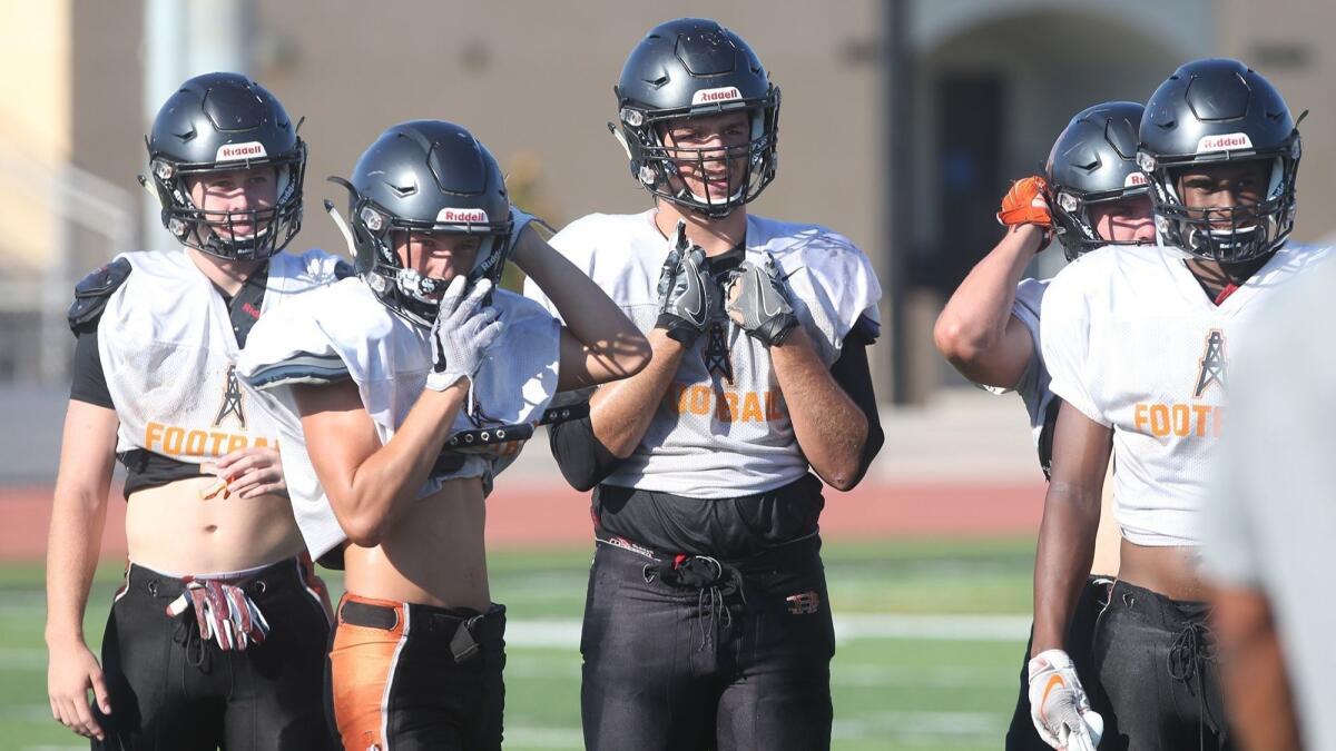 Christian Moore, center, is a linebacker and tight end for Huntington Beach High.