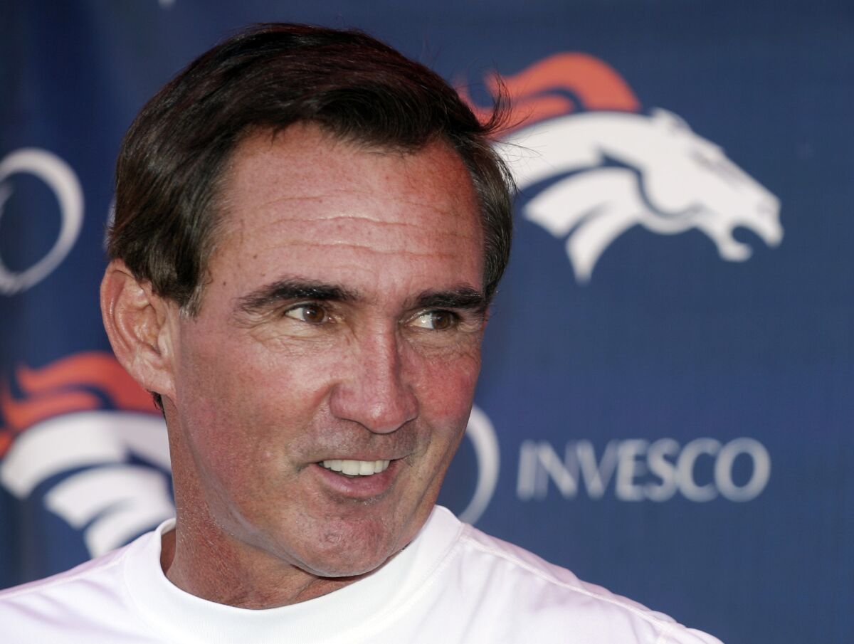 FILE - Denver Broncos head coach Mike Shanahan laughs as he talks to the media following the morning session of football training camp in Denver, in this Sunday, July 29, 2007, file photo. The Denver Broncos are celebrating Mike Shanahan' coaching contributions during their alumni weekend. Shanahan, who holds the franchise record with 146 victories between 1995-2008, including eight in the playoffs, will go into the Broncos' Ring of Fame during halftime of the Raiders-Broncos game on Sunday, Oct. 17, 2021. (AP Photo/Jack Dempsey, File)