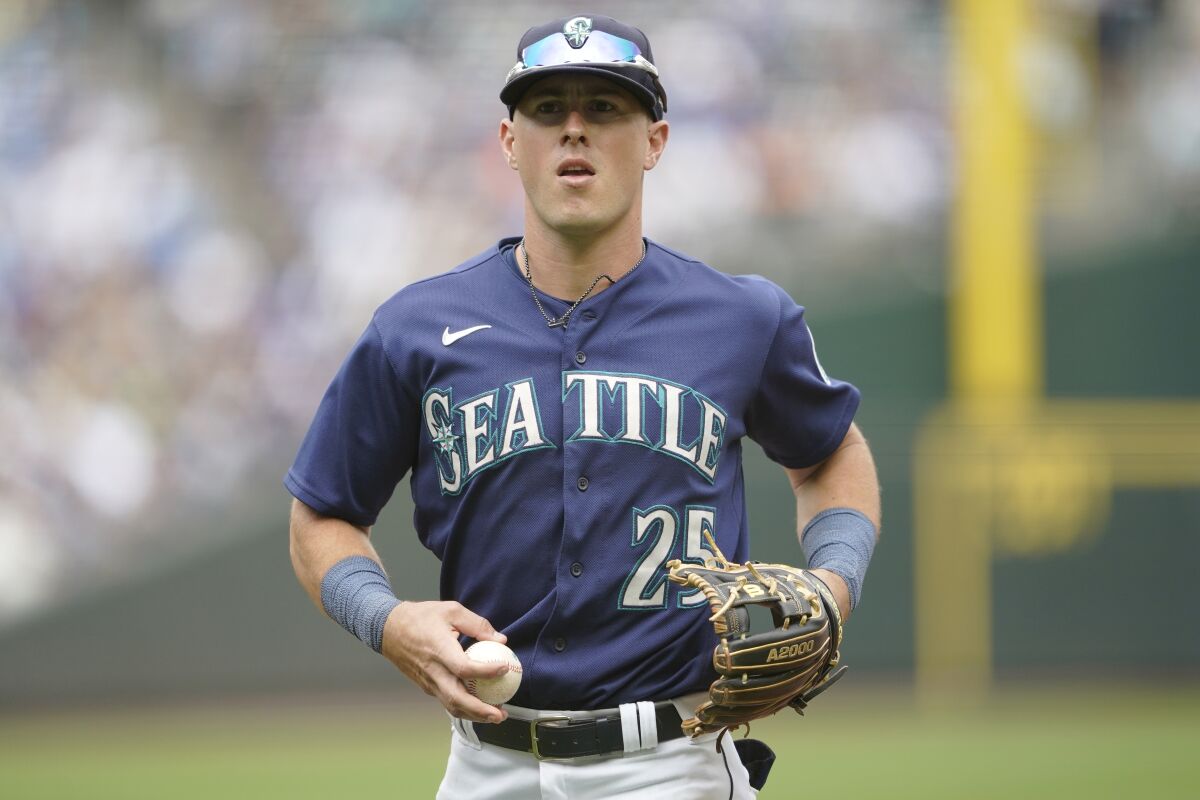 FILE -Seattle Mariners shortstop Dylan Moore jogs in with the ball after the top of the second inning of a baseball game against the New York Yankees, Wednesday, Aug. 10, 2022, in Seattle. Utilityman Dylan Moore and the Seattle Mariners have agreed to a three-year contract worth $8,875,000, avoiding a salary arbitration hearing, two people familiar with the deal told The Associated Press, Wednesday, Feb. 1, 2023. (AP Photo/Ted S. Warren, File)