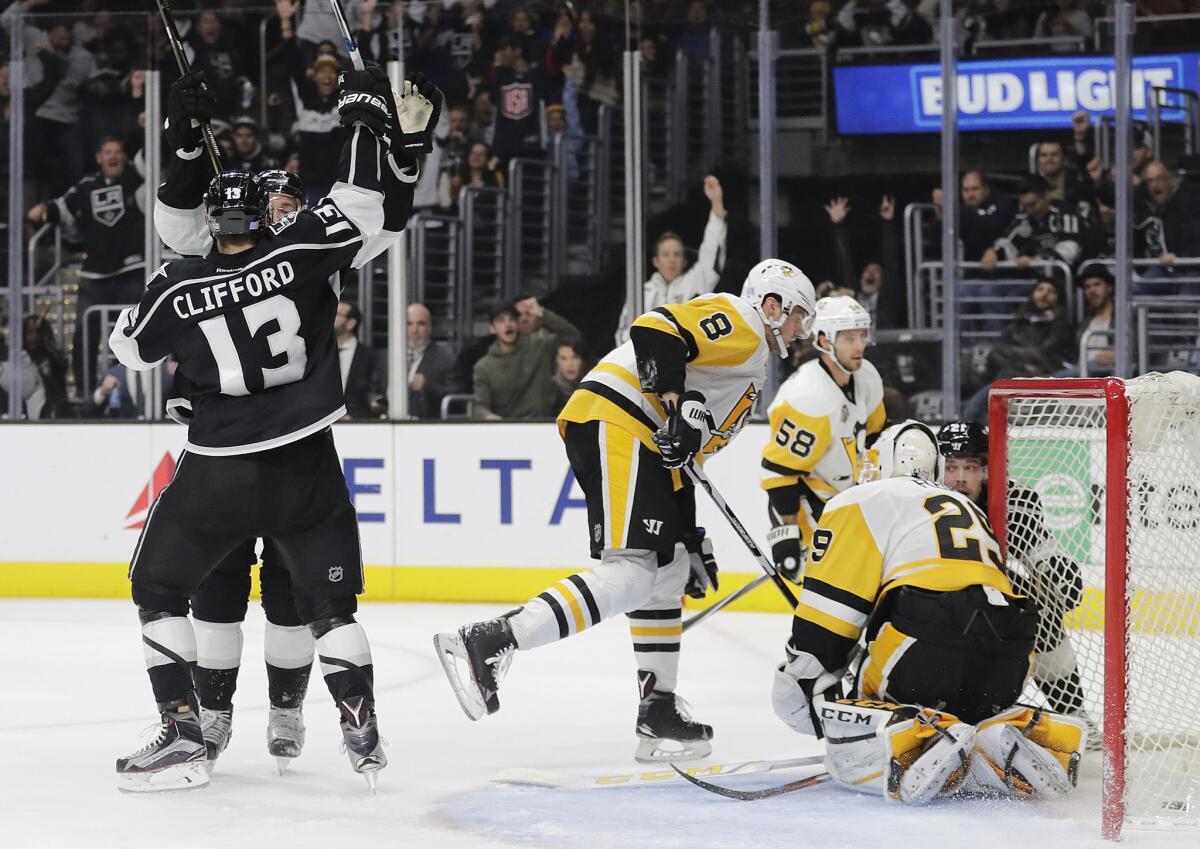 Kings forward Kyle Clifford (13) and Trevor Lewis celebrate a goal by Lewis in front of Penguins goalie Marc-Andre Fleury and Brian Dumoulin during the second period.