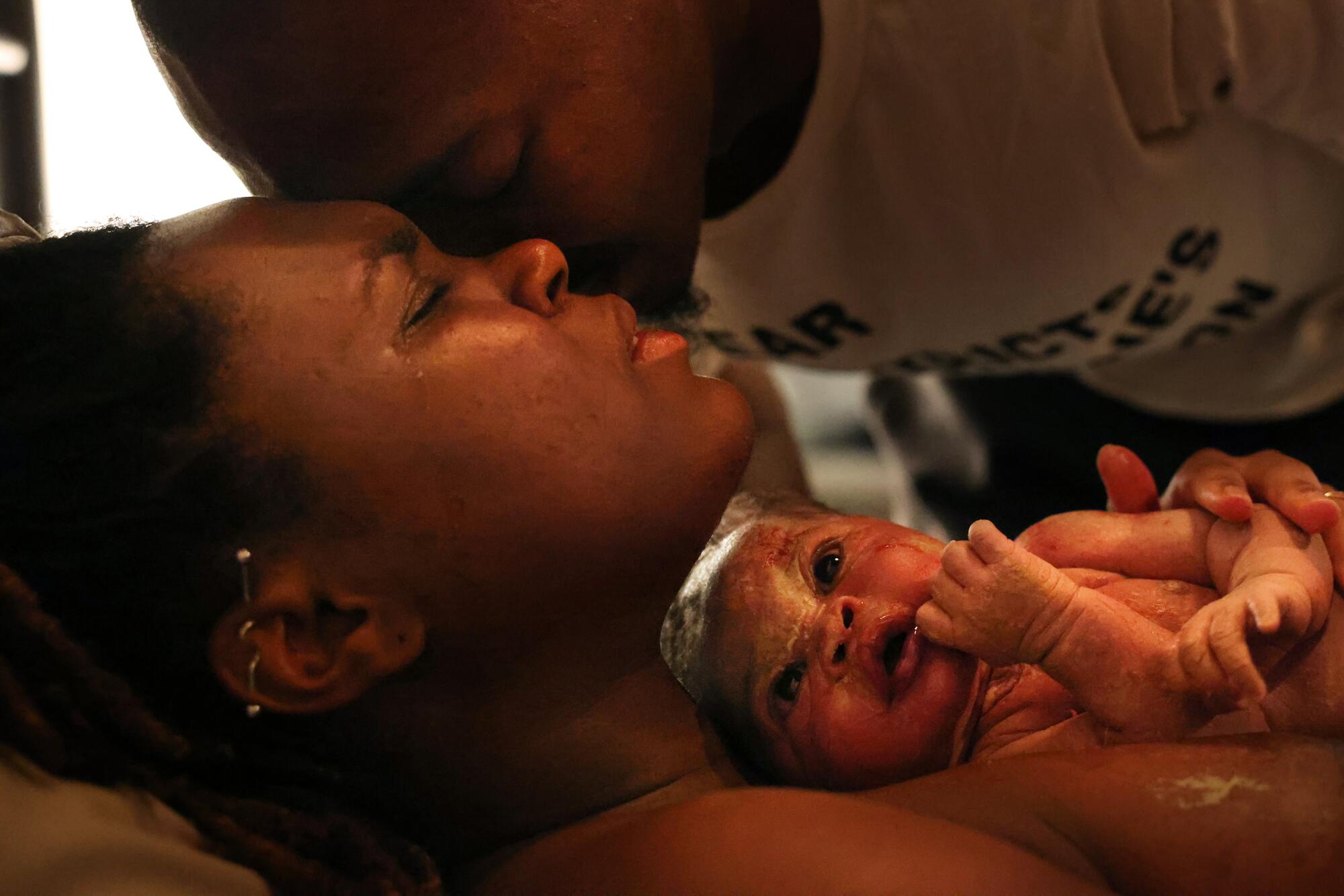 A woman with her husband and their new baby