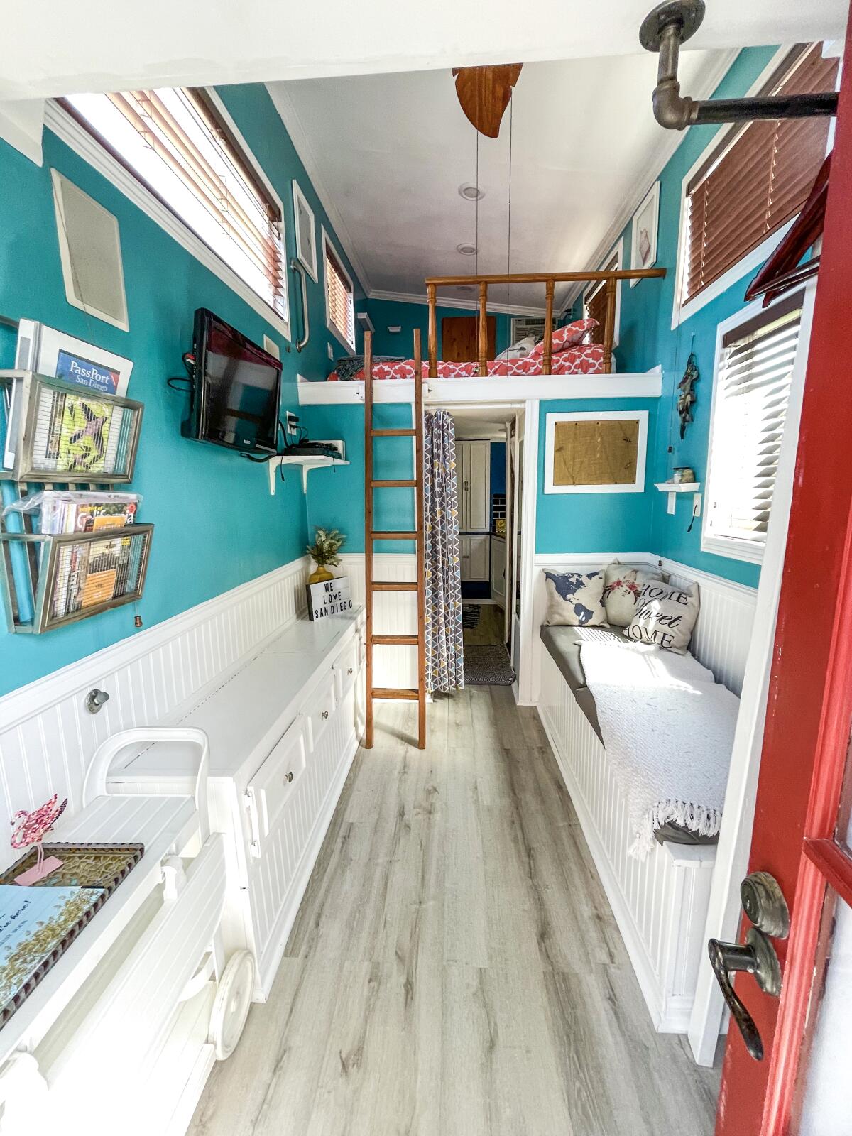 The interior of a tiny house looking up at a sleeping loft