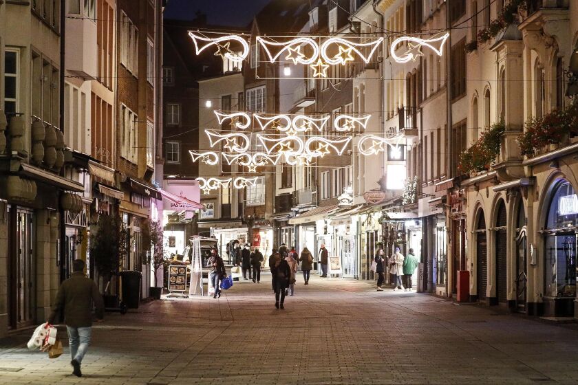 Christmas lights shine over a virtually empty shopping street in the old town of Duesseldorf, Germany, on Monday afternoon, Dec. 14, 2020. Chancellor Angela Merkel and the governors of Germany’s 16 states agreed Sunday to step up the country’s lockdown measures beginning Wednesday and running to Jan. 10 to stop the exponential rise of COVID-19 cases. (AP Photo/Martin Meissner)
