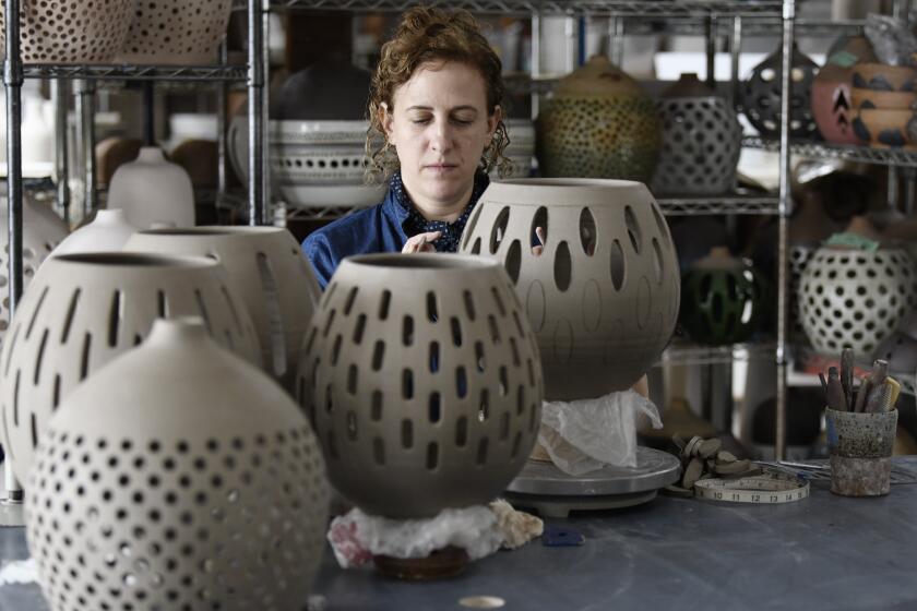 Ceramicist and artist Heather Levine works on a pendant in her studio.