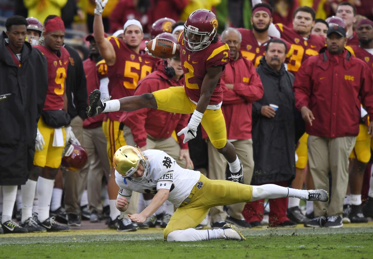 USC defensive back Adoree' Jackson (2) jumps over Notre Dame kicker John Chereson as he returns a kickoff 97 yards for a touchdown during the second half on Nov. 26.