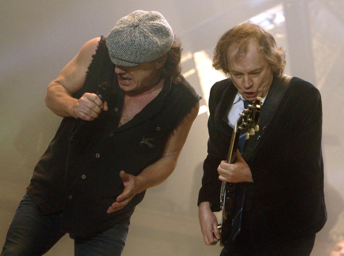 Angus Young, right, and Brian Johnson of AC/DC perform at the Los Angeles Forum in 2008.