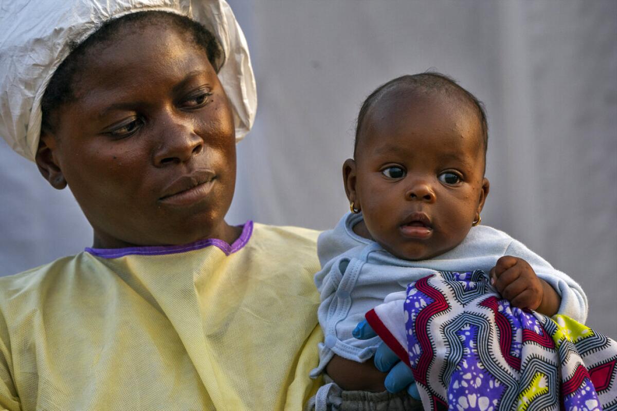 En esta image, tomada el 17 de julio de 2019, Lahya Kathembo, de dos meses, espera en los brazos de una enfermera a los resultados de una prueba de ébola en un centro de tratamiento de la enfermedad en Beni, República Democrática del Congo.
