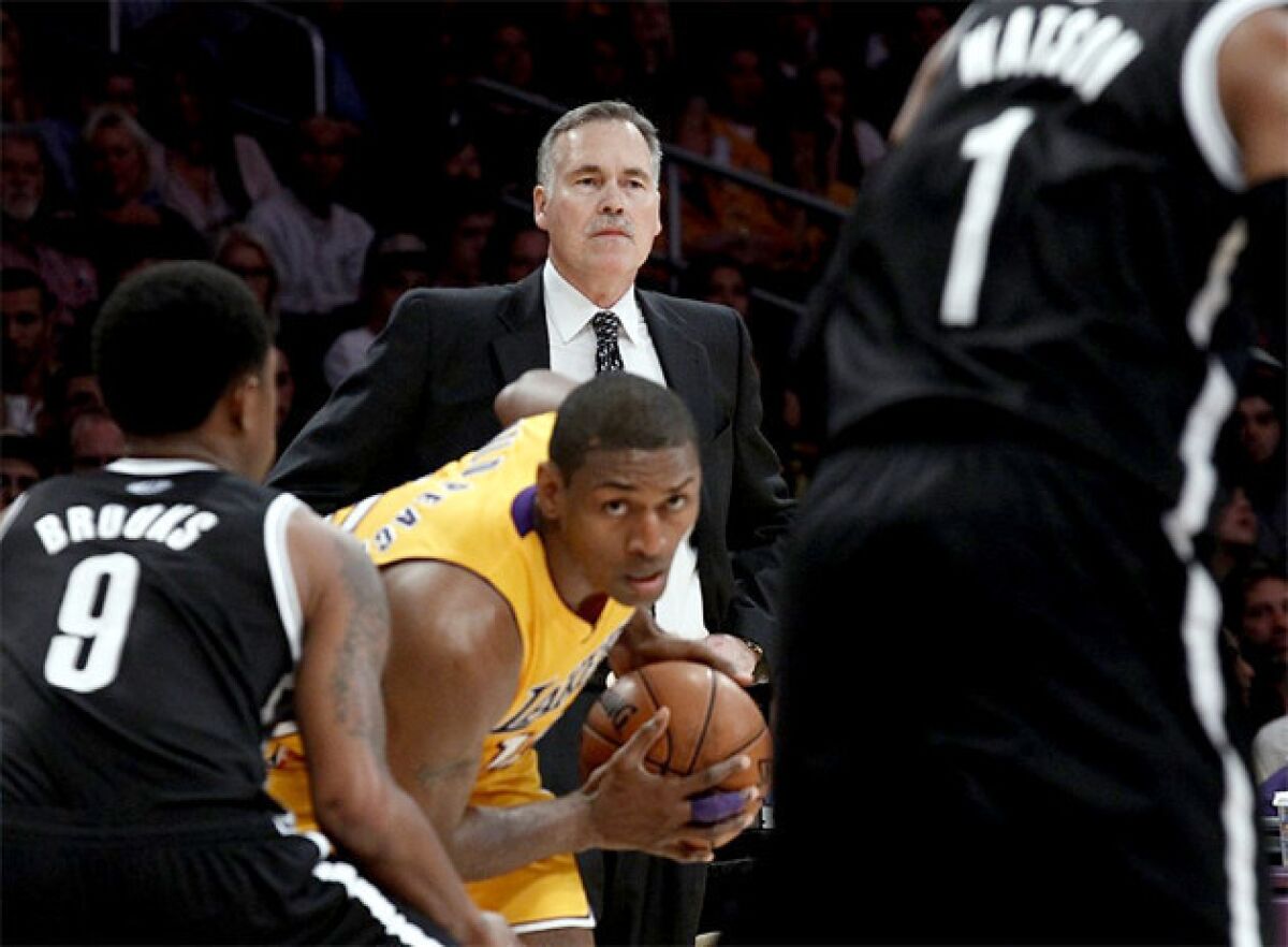 Mike D'Antoni watches his team on the offensive end of the floor while Metta World Peace maneuvers with the ball.