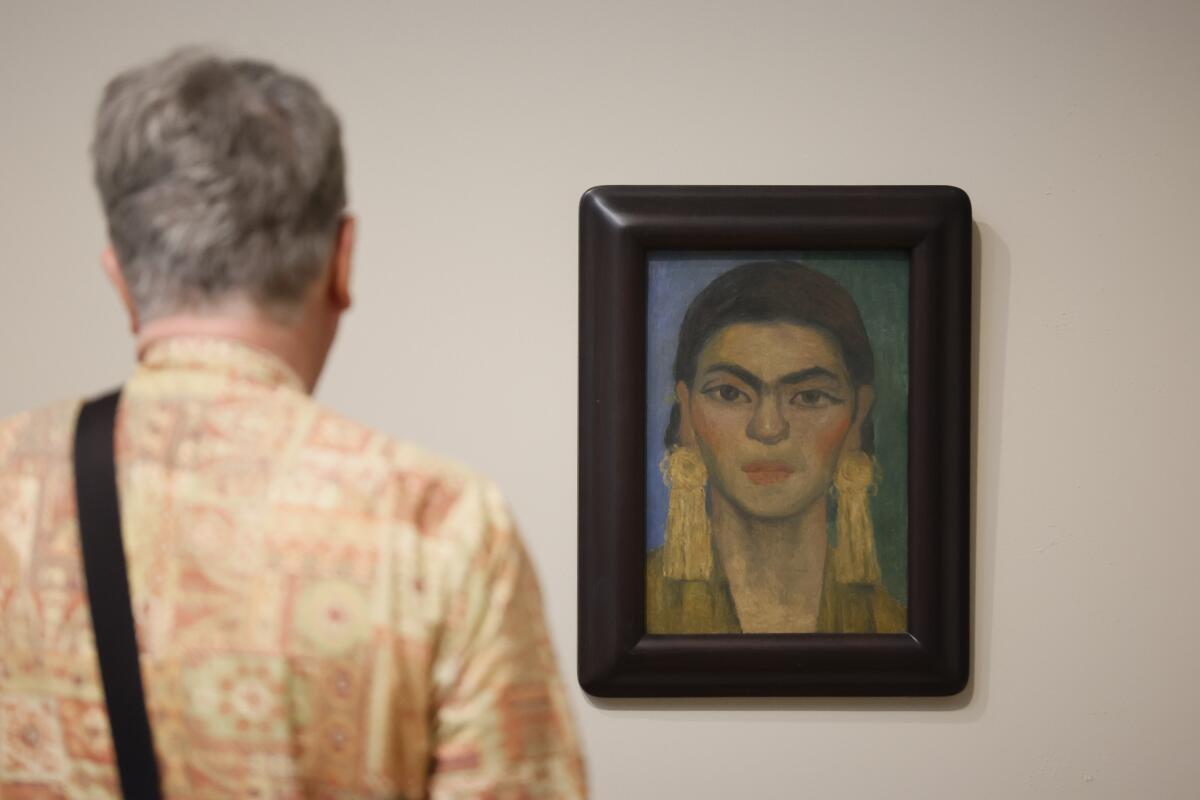 A person looks at a Frida Kahlo painting