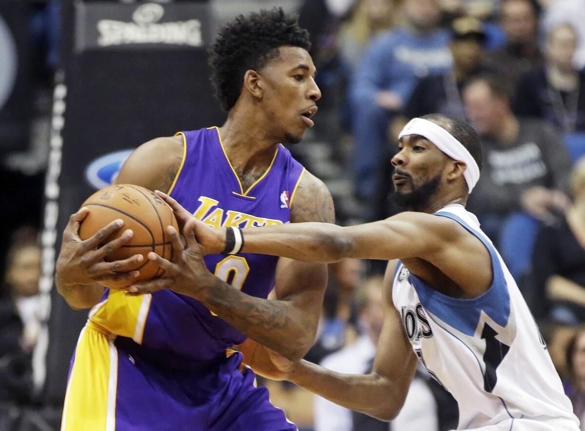Nick Young tries to keep the ball away from Minnesota's Corey Brewer during the first quarter Tuesday at the Target Center in Minneapolis. Young went down with a knee injury against Cleveland on Wednesday.