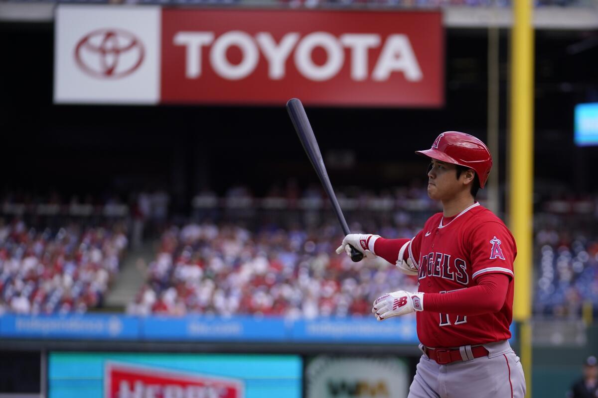 The Angels' Shohei Ohtani holds out his bat at a game.