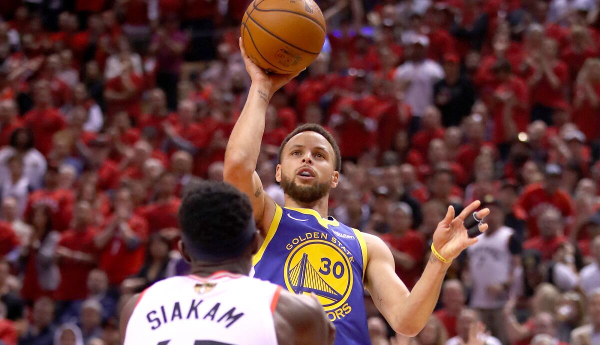 Warriors guard Stephen Curry attempts a shot over Raptors forward Pascal Siakam during the first half of Game 2.