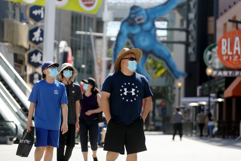 UNIVERSAL CITY, CA - JULY 02: A family wearing mask at Universal City Walk Hollywood on Thursday, July 2, 2020 in Universal City, CA. There was very few guests. Gov. Gavin Newsom on Wednesday ordered tougher restrictions on indoor activities for most of the state due to increase in coronavirus cases. (Gary Coronado / Los Angeles Times)