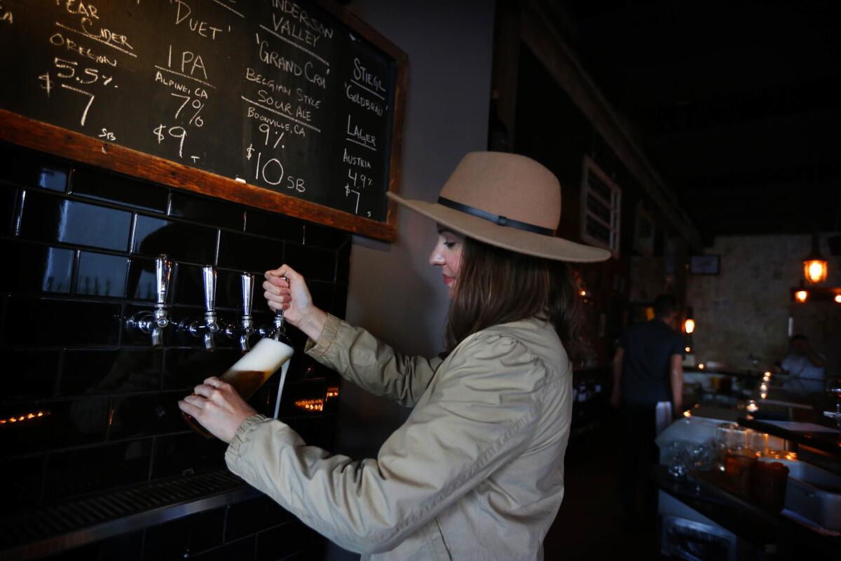 Bartender Kerry Vasquez pours a beer at Covell.