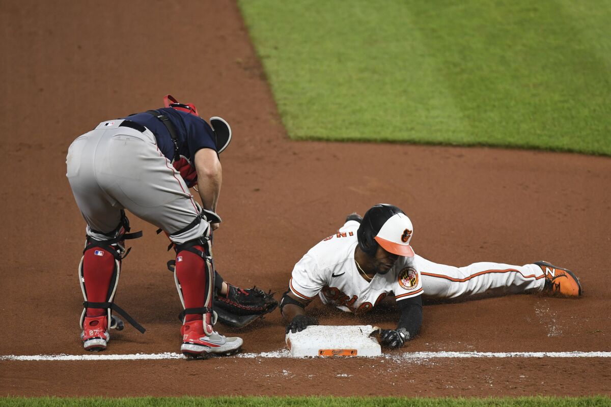 Baltimore Orioles Cedric Mullins slides into third and avoids tag from Boston Red Sox catcher Christian Vazquez for eighth inning triple during a baseball game Monday, May 10, 2021, in Baltimore. (AP Photo/Terrance Williams)