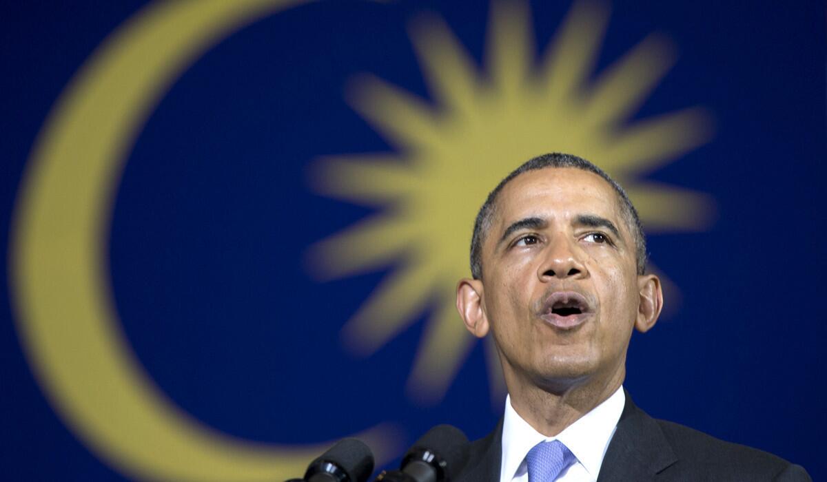 President Obama, framed by the Malaysian flag behind him, speaks at a town hall meeting at Malaya University in Kuala Lumpur on Sunday.