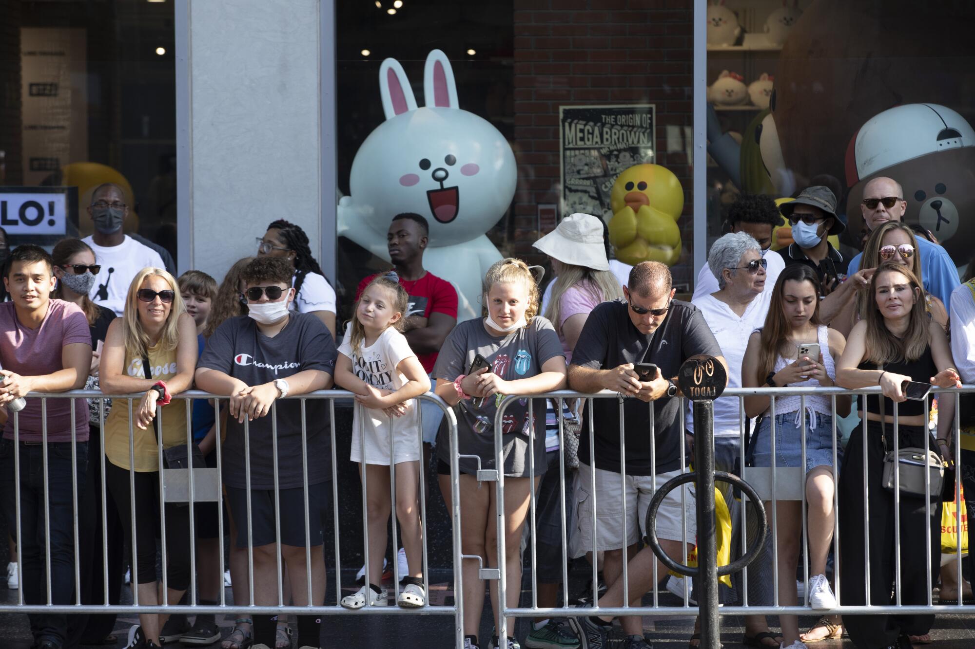 Fans line up on Hollywood Boulevard behind metal barriers