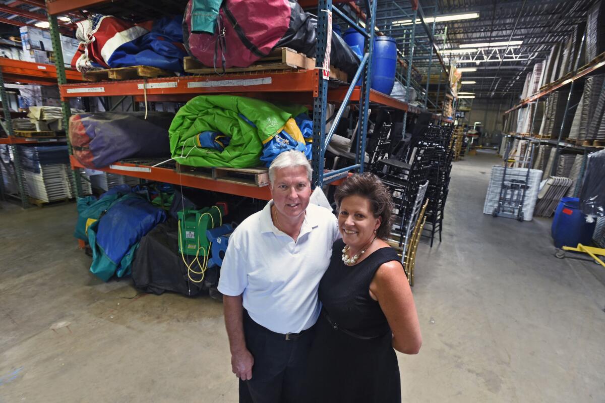 Leroy and Lauri Dixon, the husband and wife owners of Party Plus, a tents and event rentals company, stand in their warehouse in Glen Burnie, Md., on Sept. 17.