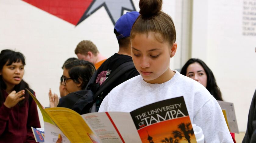 Sophomore Kimberly Vargas looks over information about the University of Tampa during a college fair at Glendale High School on Wednesday.