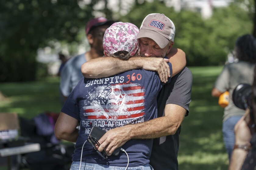 Activist and entertainer Jon Stewart hugs fellow advocate Susan Zeier of Sandusky, Ohio