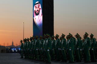 Saudi security forces stand at attention beneath a portrait of Saudi Arabia's crown prince, Mohammed bin Salman.