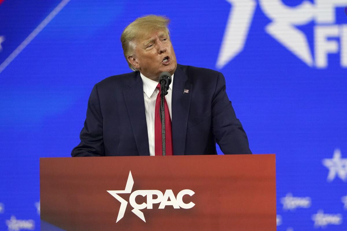 Former President Trump speaks at lectern with the CPAC logo