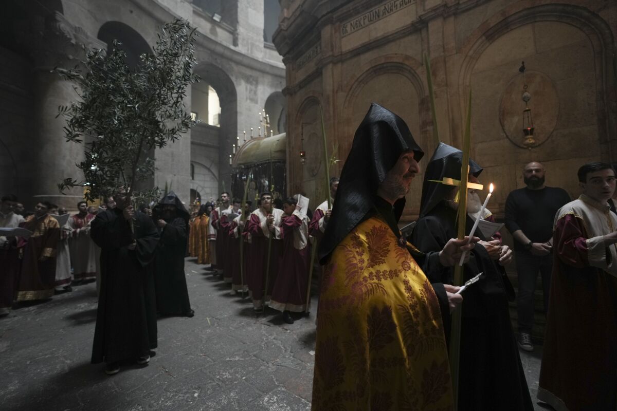Orthodox Christian clergy marks Palm Sunday at the Church of the Holy Sepulchre, a place where Christians believe Jesus Christ was crucified, buried and resurrected, in Jerusalem, Sunday, April 17, 2022. (AP Photo/Oded Balilty)