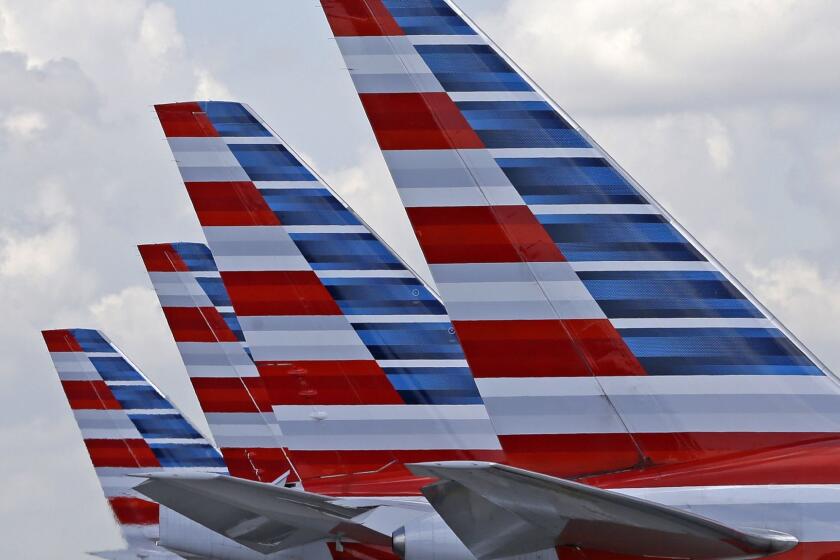 FILE - This July 17, 2015, file photo shows the tails of four American Airlines passenger planes parked at Miami International Airport, in Miami. On Tuesday, March 14, 2017, American said it will offer free meals to everyone in economy on certain cross-country flights starting May 1, 2017. The decision at the world's biggest airline copies Delta Air Lines, which announced a month earlier that it would restore free meals in economy on a dozen long-haul U.S. routes in spring 2017. (AP Photo/Alan Diaz, File)