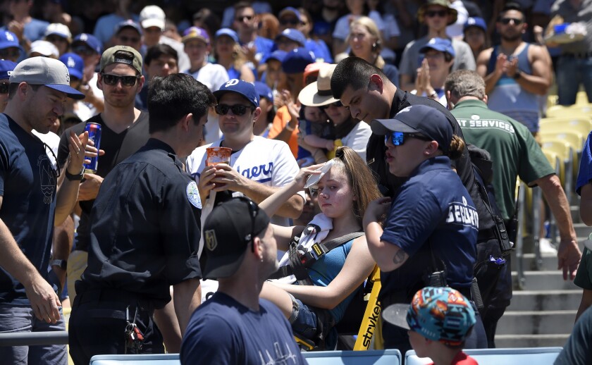 A young fan is carted away after being hit with a foul ball hit from the bat of the Dodgers' Cody Bellinger during the first inning of a game against the Rockies on June 23 at Dodger Stadium.
