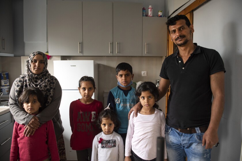 Abdul Salam Al Khawien, 37, right, and his wife Kariman, 32, left, pose with their children for a family photo, at their apartment in the northern city of Thessaloniki, Greece, Saturday, May 1, 2021. Sundered in the deadly chaos of an air raid, a Syrian family of seven has been reunited, against the odds, three years later at a refugee shelter in Greece's second city of Thessaloniki. (AP Photo/Giannis Papanikos)