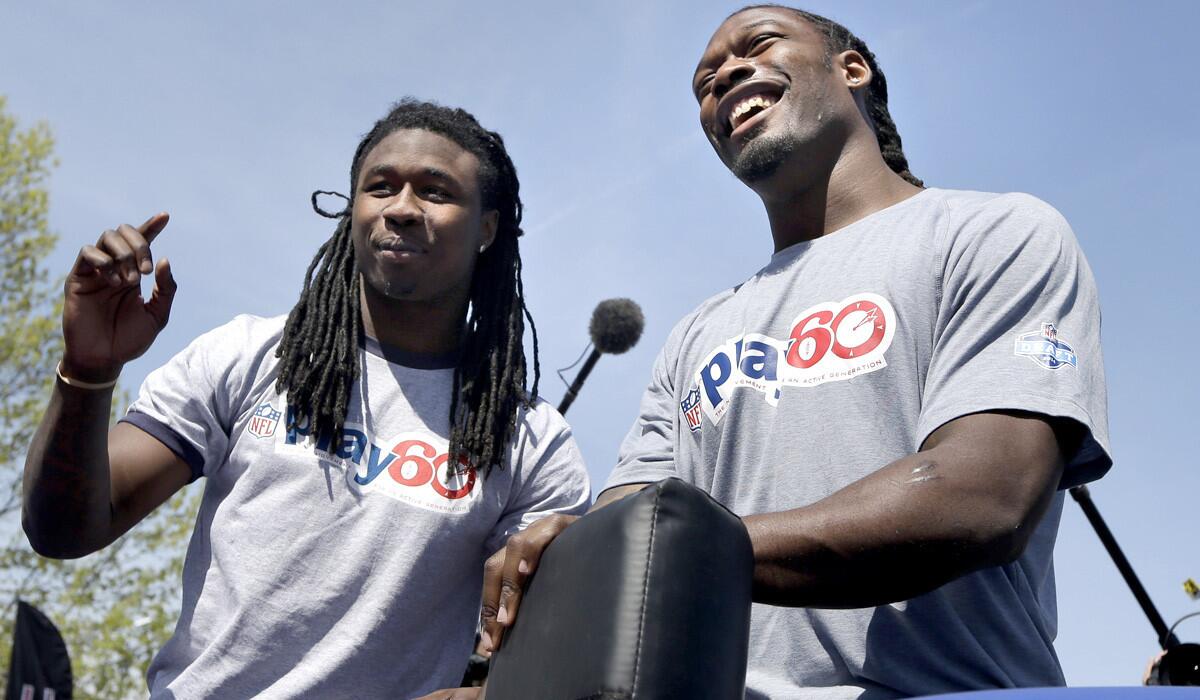 Receiver Sammy Watkins, left, and defensive end Jadeveon Clowney talk to kids about tackling technique during a "Play 60" event in New York on Wednesday. Each player is expected to be chosen in the first few picks of the draft on Thursday.